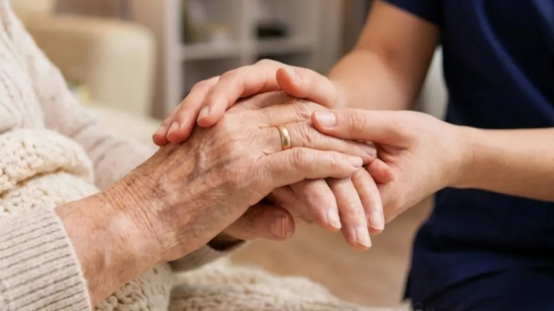 A caregiver holding an older woman's hands